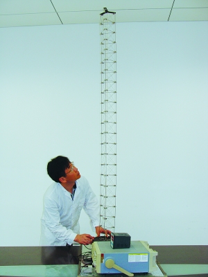 這是伸展開(kāi)的衛(wèi)星太陽(yáng)能電池用盤壓伸桿，20厘米長(zhǎng)螺旋狀的盤壓伸桿（右側(cè)小圖）打開(kāi)后能達(dá)2米長(zhǎng)（8月7日攝）。（新華社發(fā)）