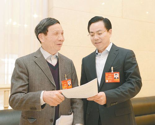 黃伯云代表（左）與劉國忠代表商討完善《關(guān)于建立戰(zhàn)略性新興產(chǎn)業(yè)國家創(chuàng)新平臺》的建議。 本報記者 張目 攝